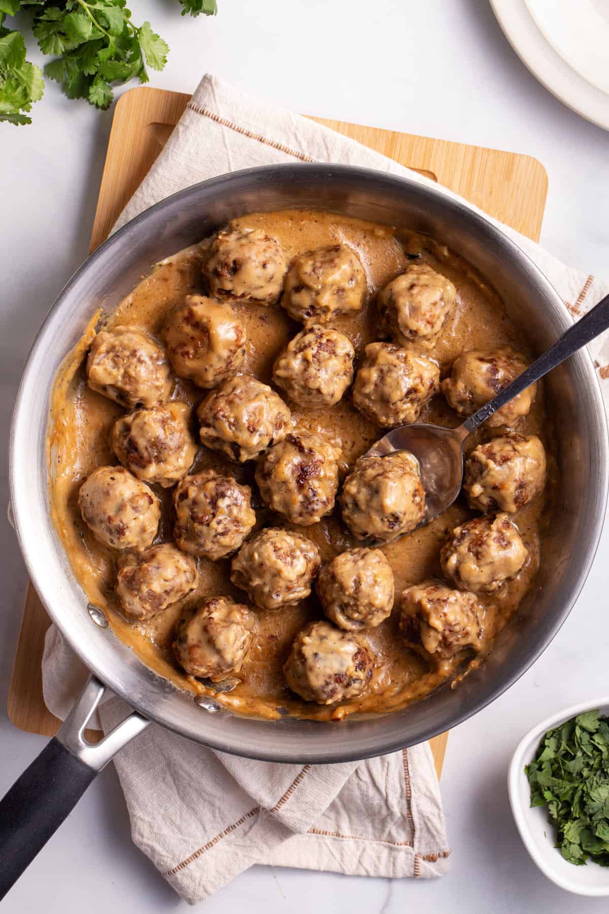 top down image of Swedish meatballs with gravy served in a stainless steel pan.