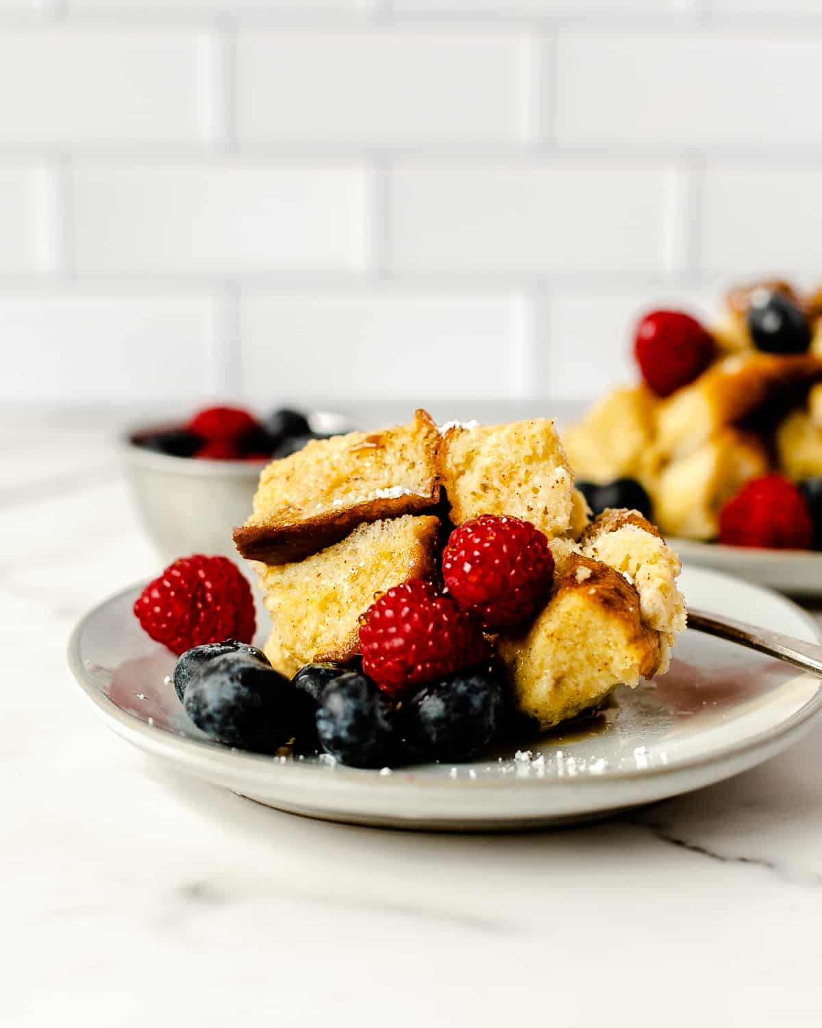 serving of crockpot french toast with fresh berries sitting on a round grey plate