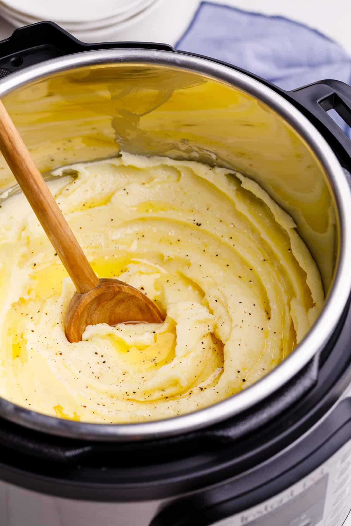 instant pot mashed potatoes with a wooden spoon