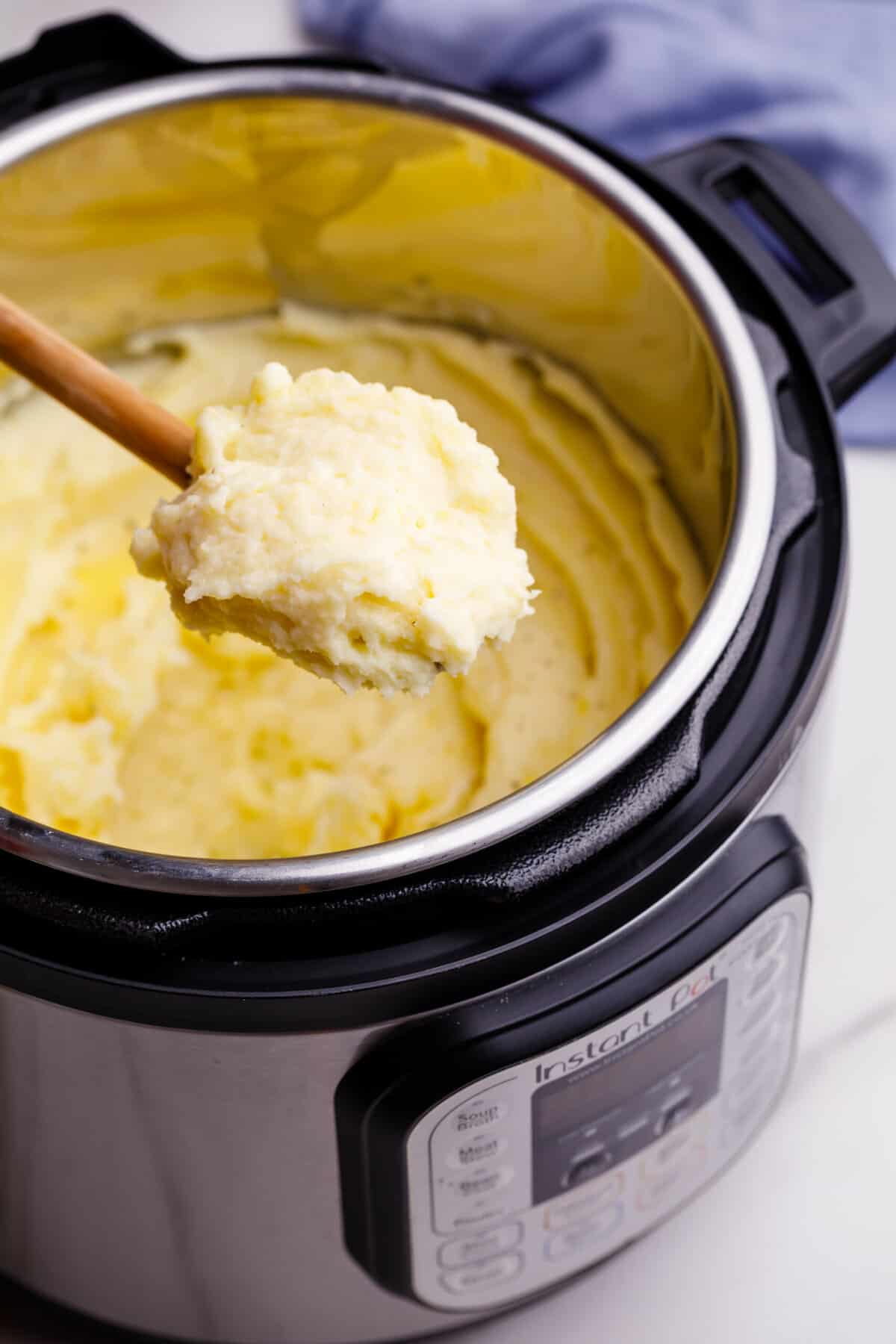 Wooden spoonful of instant pot mashed potatoes.