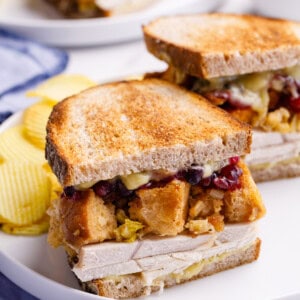 Half a leftover turkey sandwich with turkey, gravy, stuffing, and cranberry sauce.