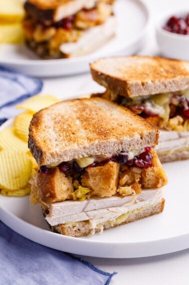 Half a leftover turkey sandwich with turkey, gravy, stuffing, and cranberry sauce.