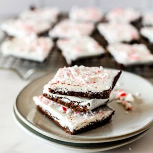 A stack of 3 peppermint bark brownies on a plate.