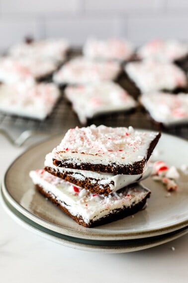 A stack of 3 peppermint bark brownies on a plate.