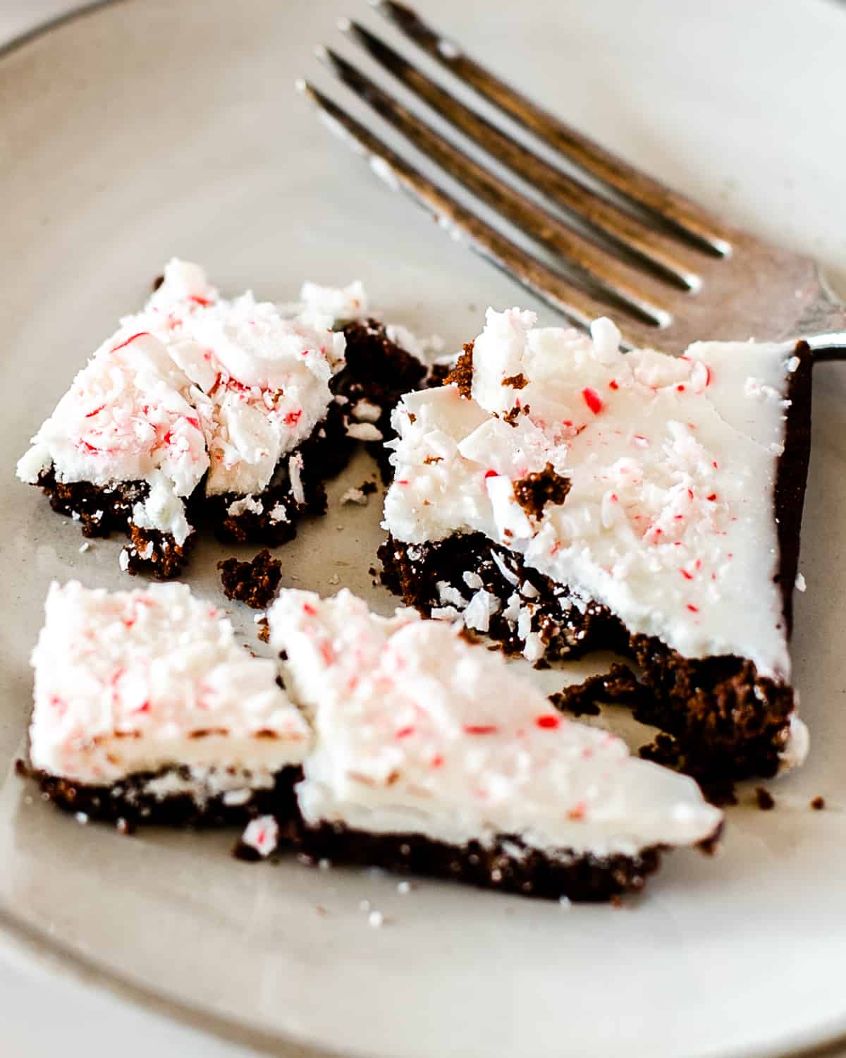 serving of peppermint bark brownies on a white round plate