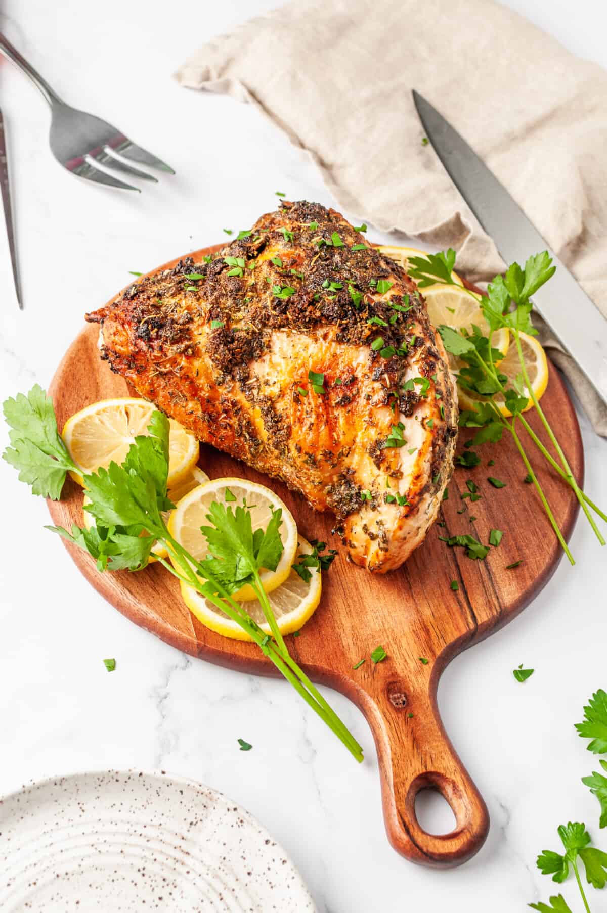 Air fryer turkey breast on a wooden cutting board.