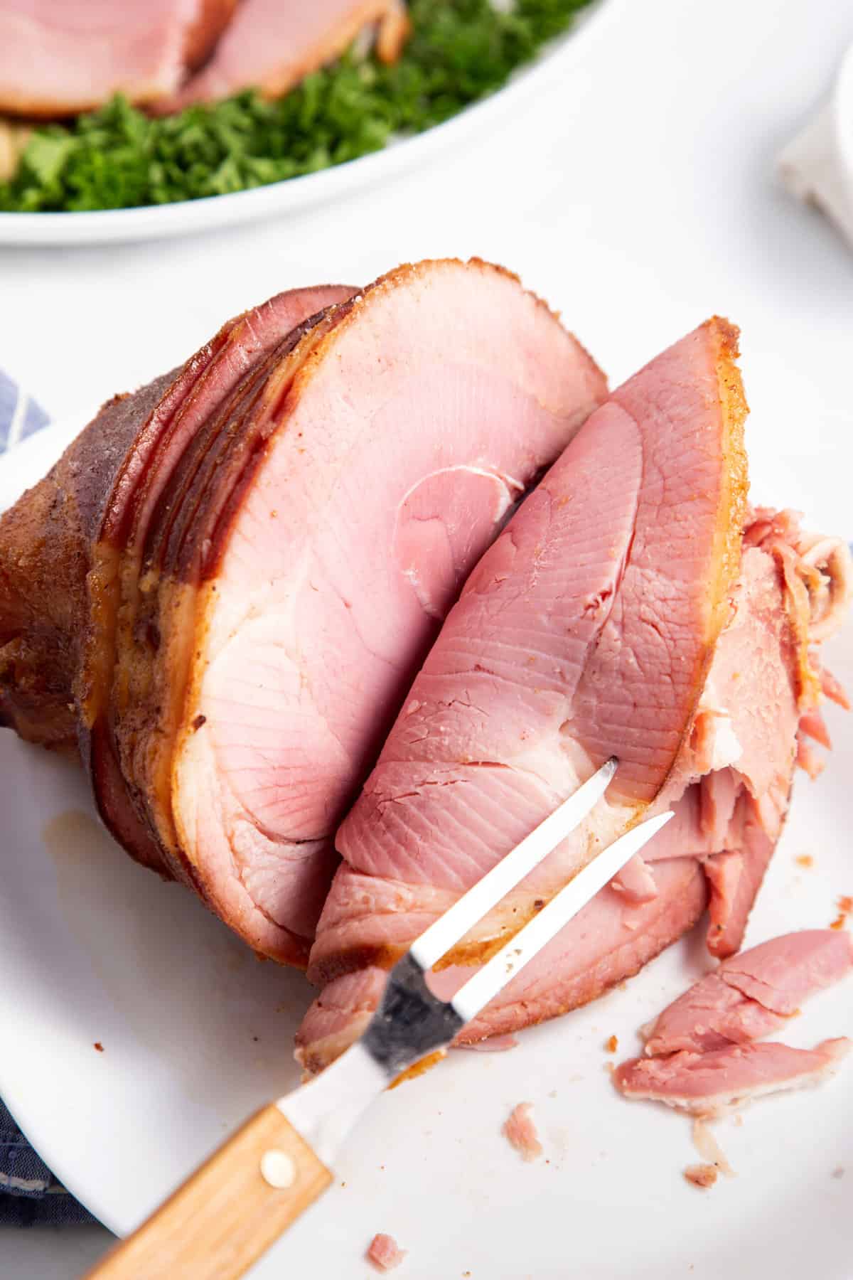 honey baked ham sliced with meat fork tools
