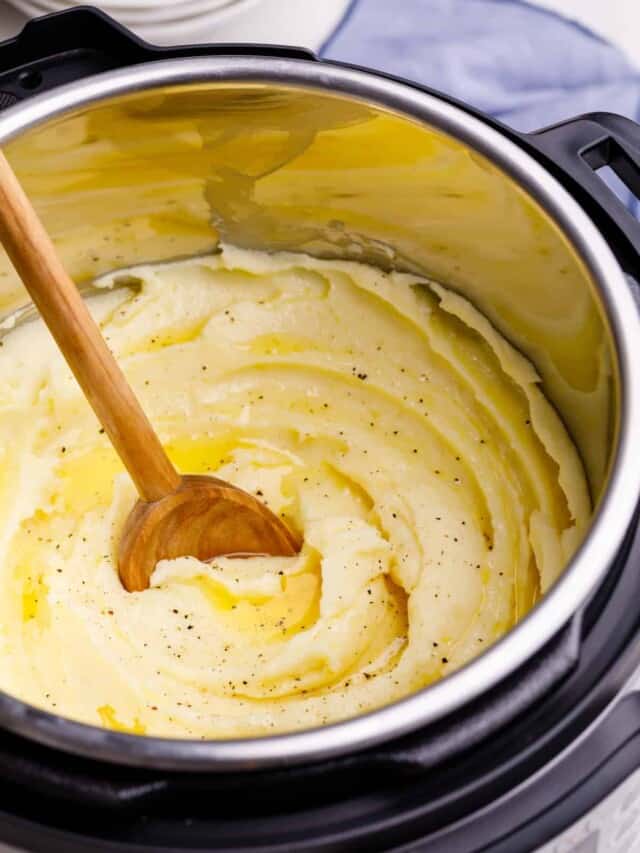 Instant Pot mashed potatoes being stirred with a wooden spoon.