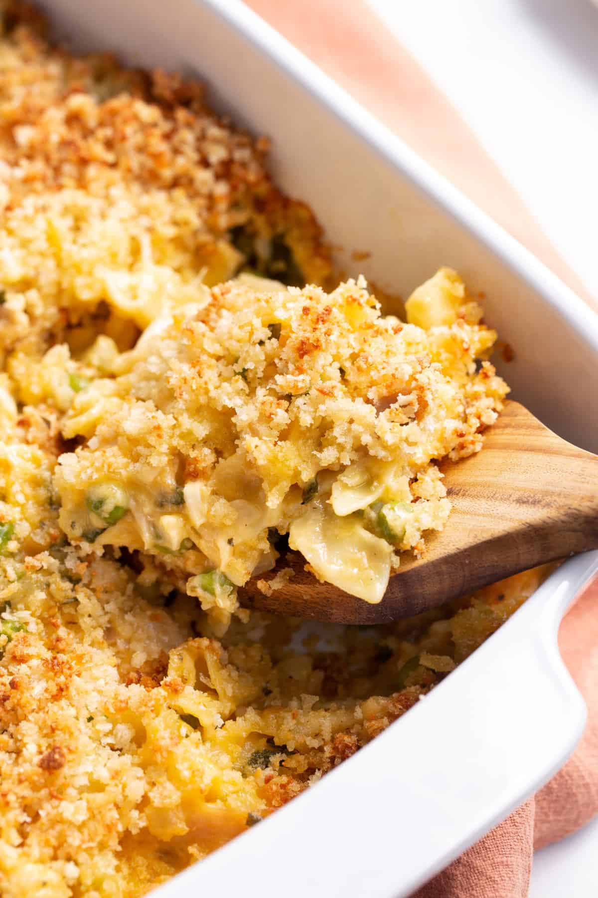 close up image of leftover turkey casserole with a wooden spatula digging in