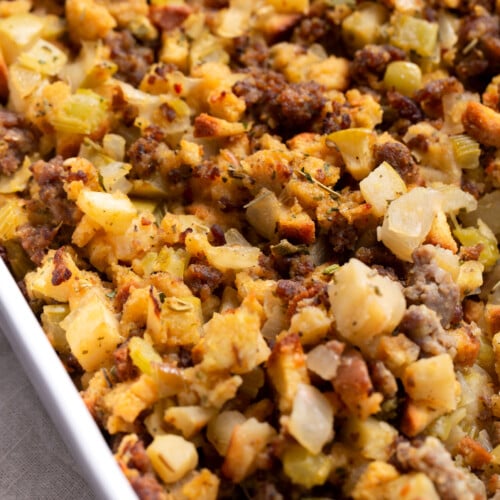 Sausage & apple stuffing in a white casserole dish.