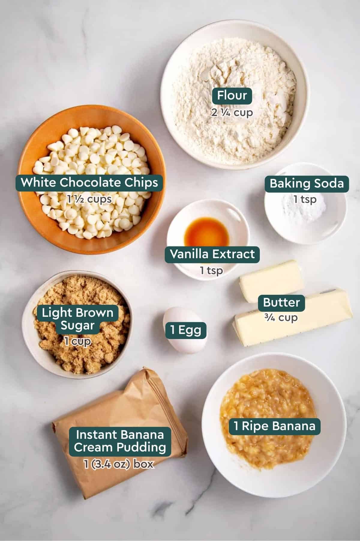 Ingredients for banana pudding cookies, including flour, white chocolate chips, baking soda, vanilla extract, butter, egg, light brown sugar, banana, and pudding mix.