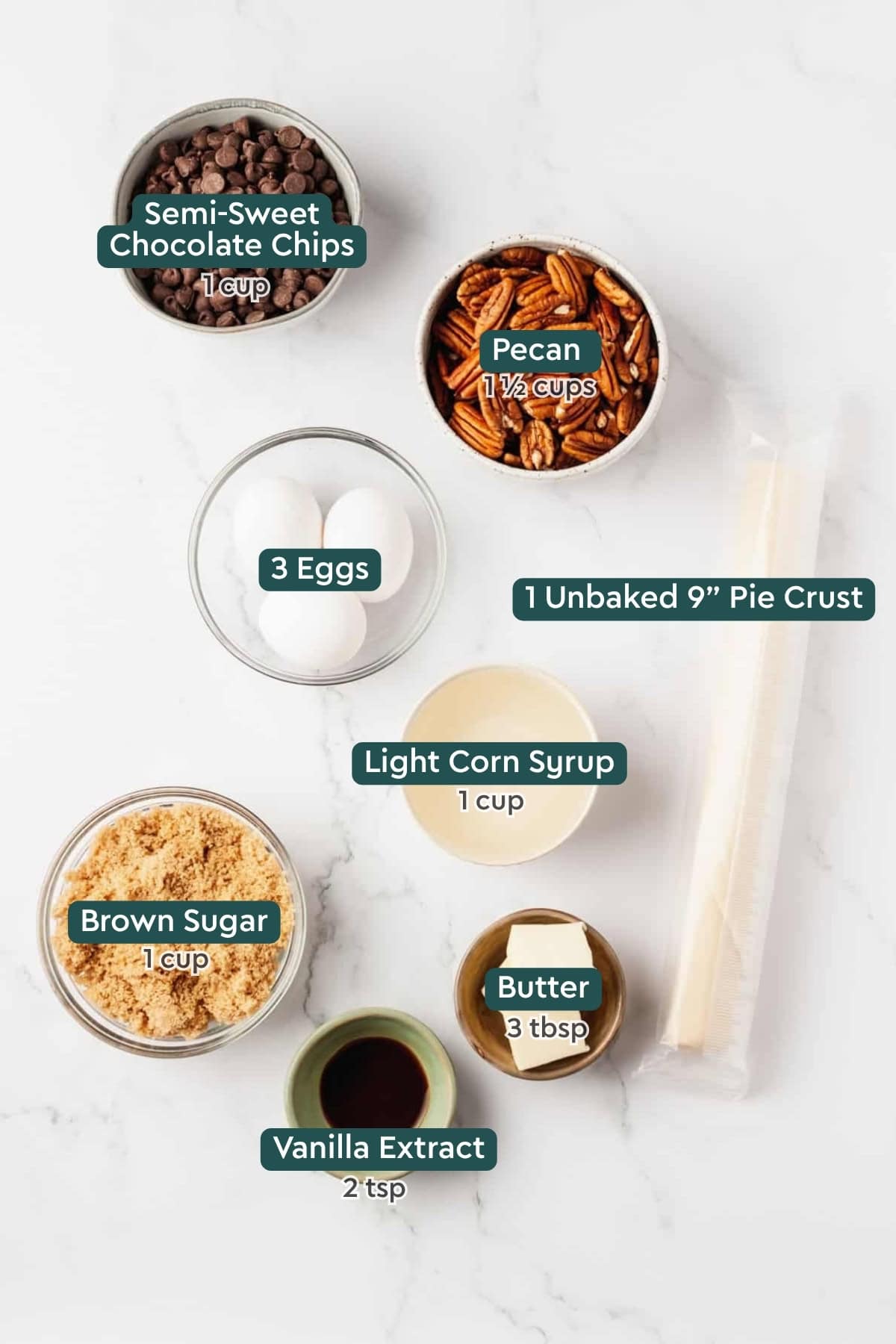 Ingredients for chocolate pecan pie, including chocolate chips, pecans, pie crust, eggs, corn syrup, brown sugar, butter, and vanilla.