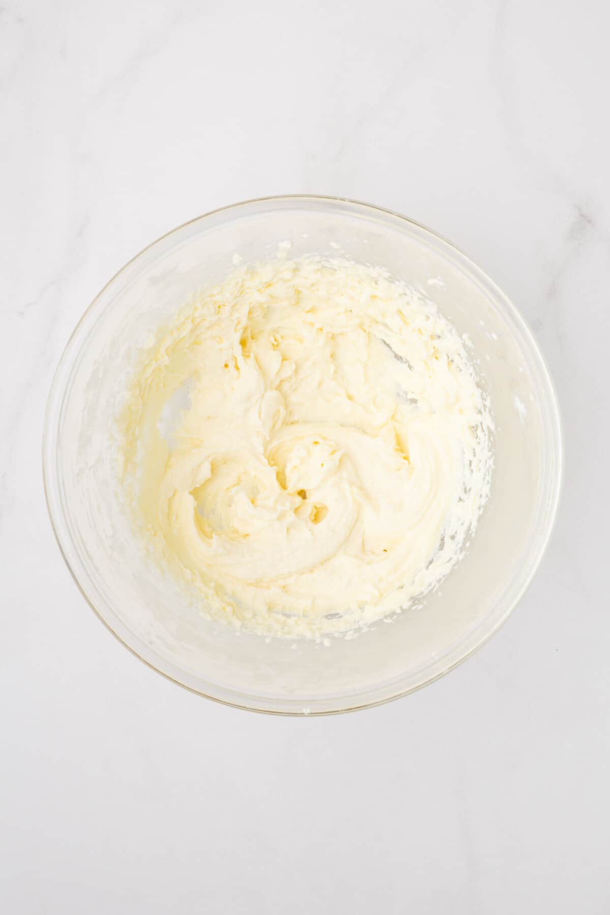 Cream cheese icing in glass bowl.