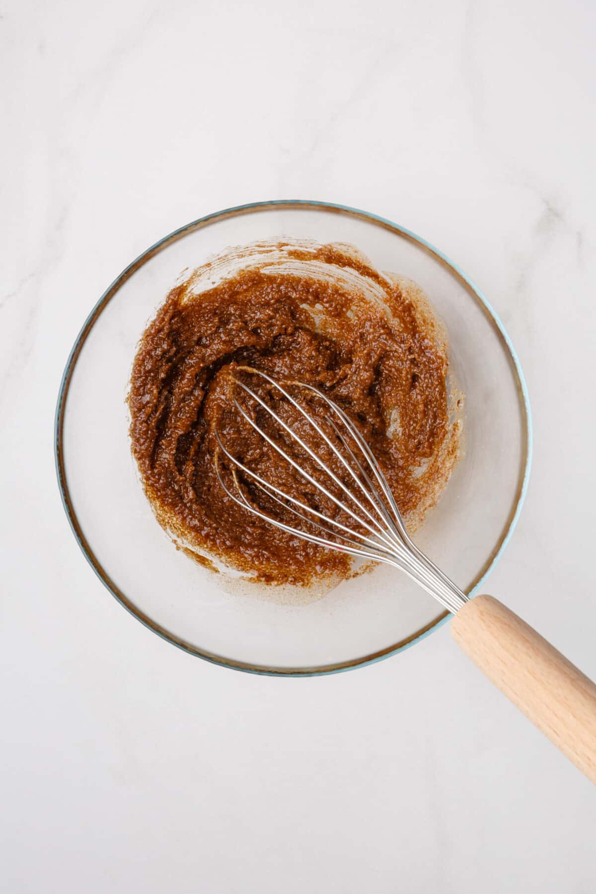Whisk in bowl with cinnamon roll pancake filling.