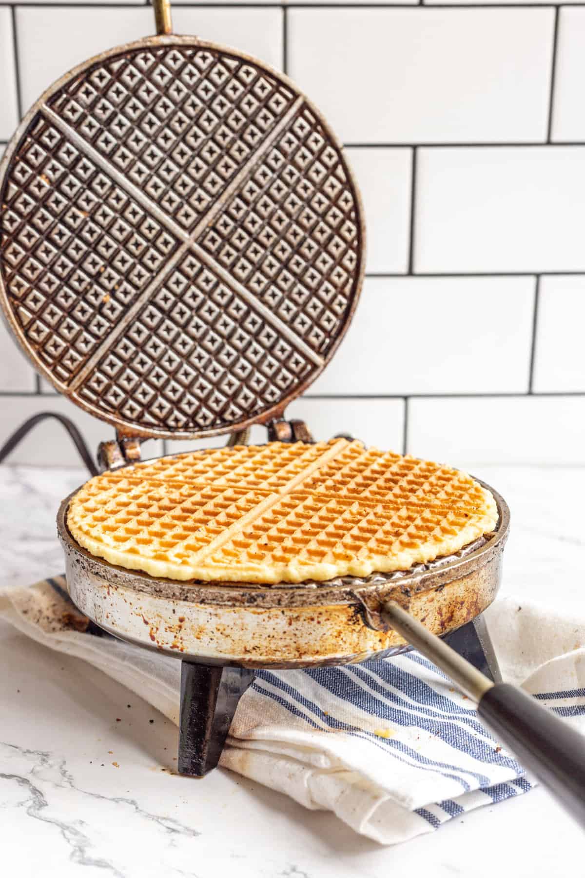 A cooked pizzelle on a pizzelle iron. 