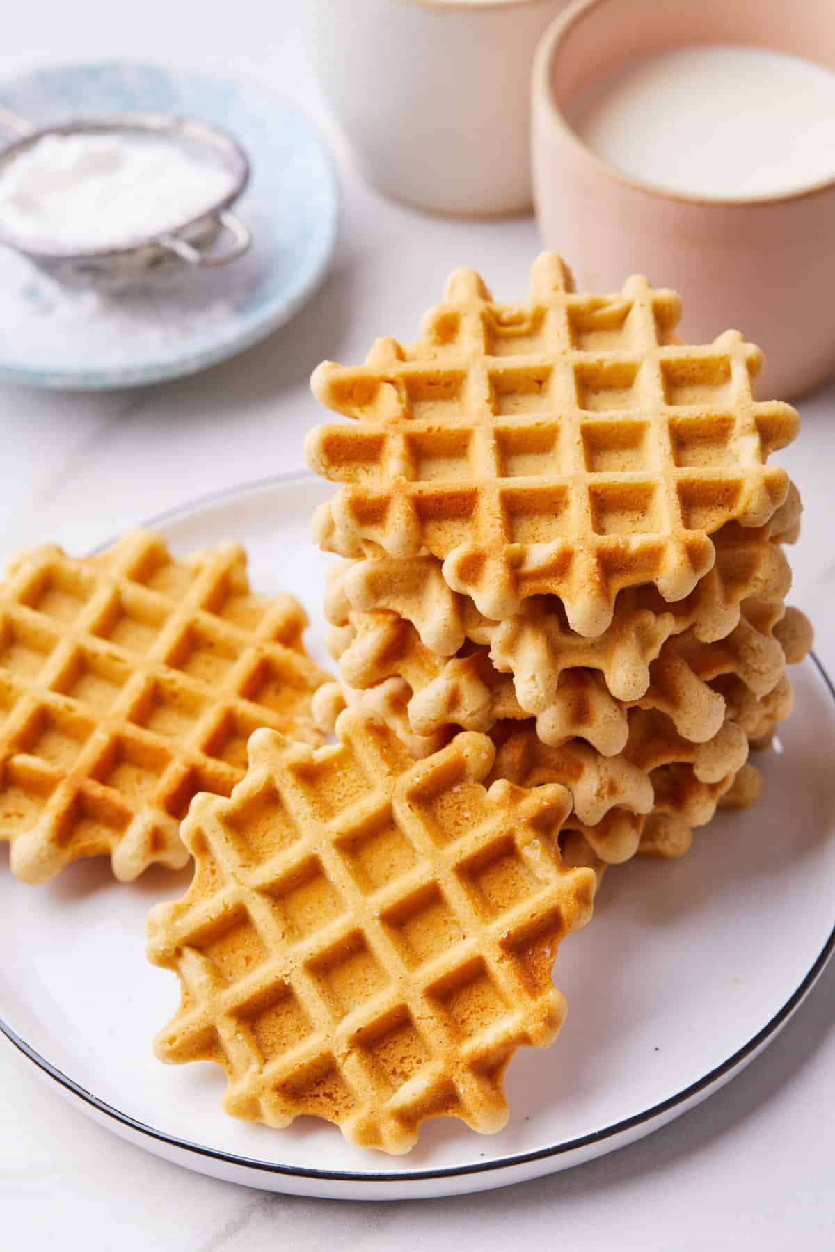 top down image of waffle cookies stacked and piled on a white round plate