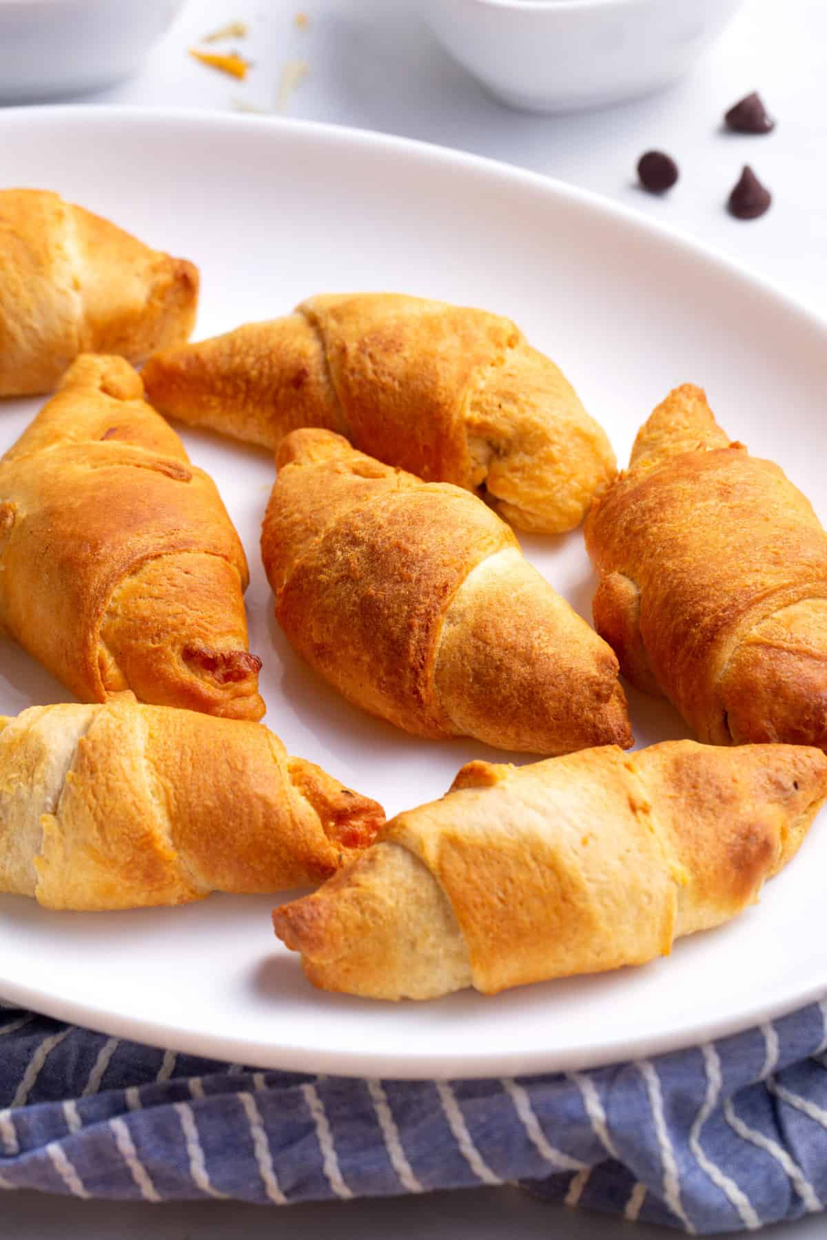 close up image of air fryer crescent rolls served on a large white oval plate