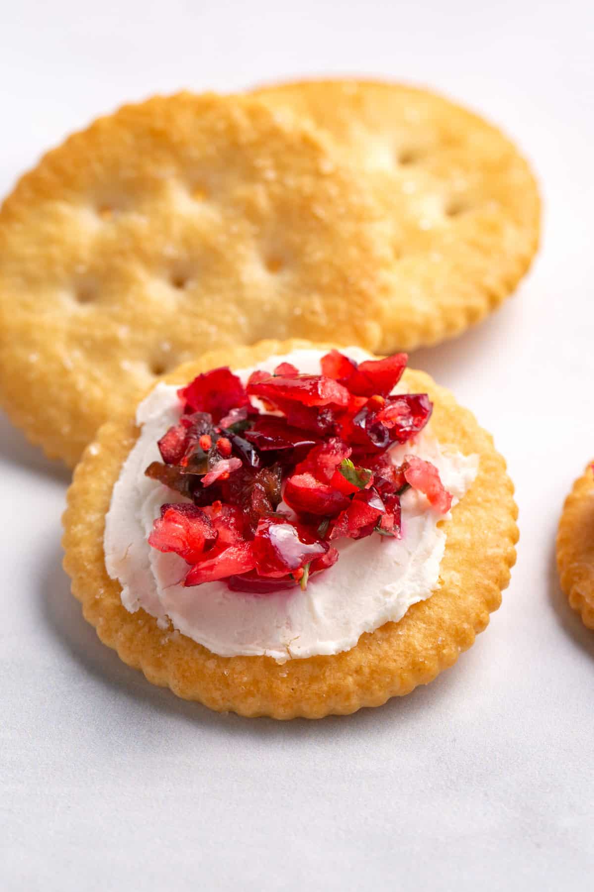 close up image of cranberry jalapeno dip served on a ritz cracker