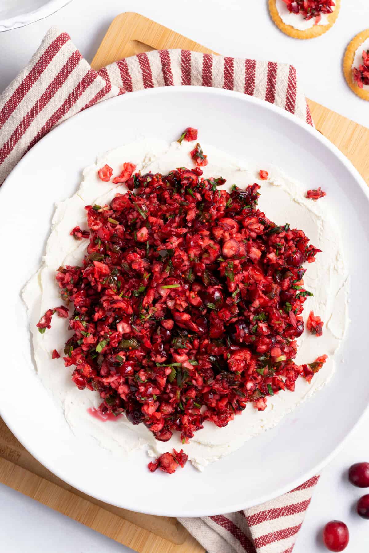 top down image of cranberry jalapeno dip served on a large white round plate
