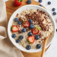 A bowl of Instant Pot oatmeal topped with blueberries, strawberries, and pecans.