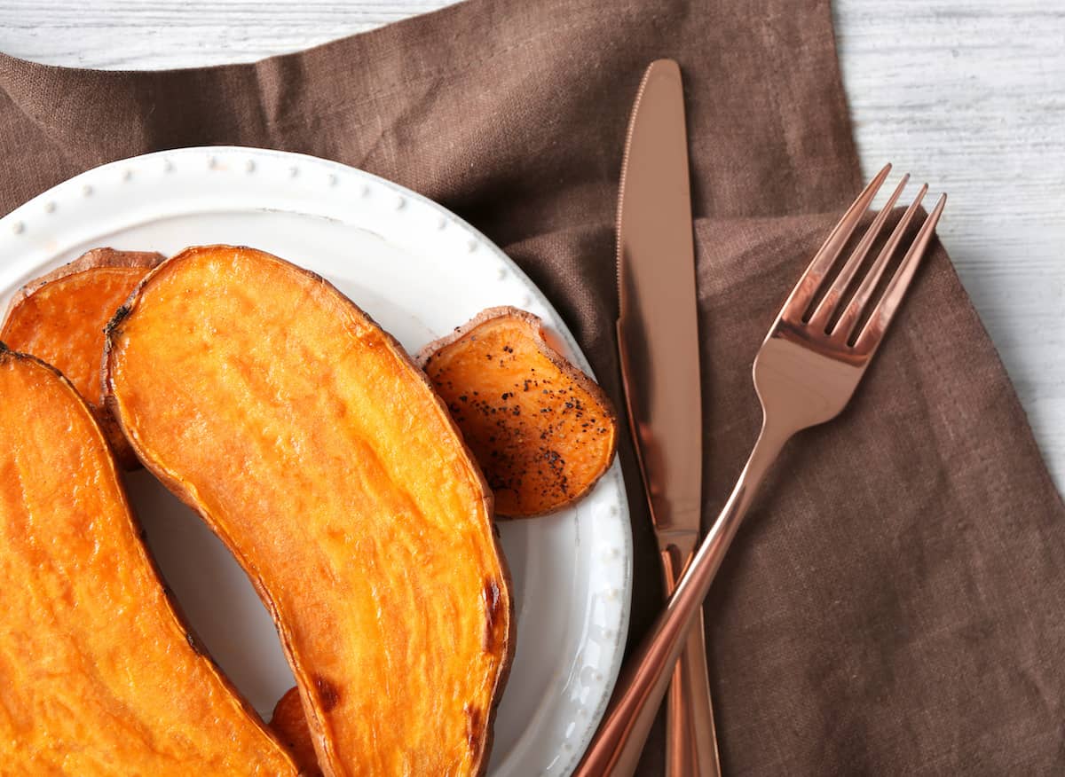sweet potato made in an instant pot served on a white round plate with rose gold silverware