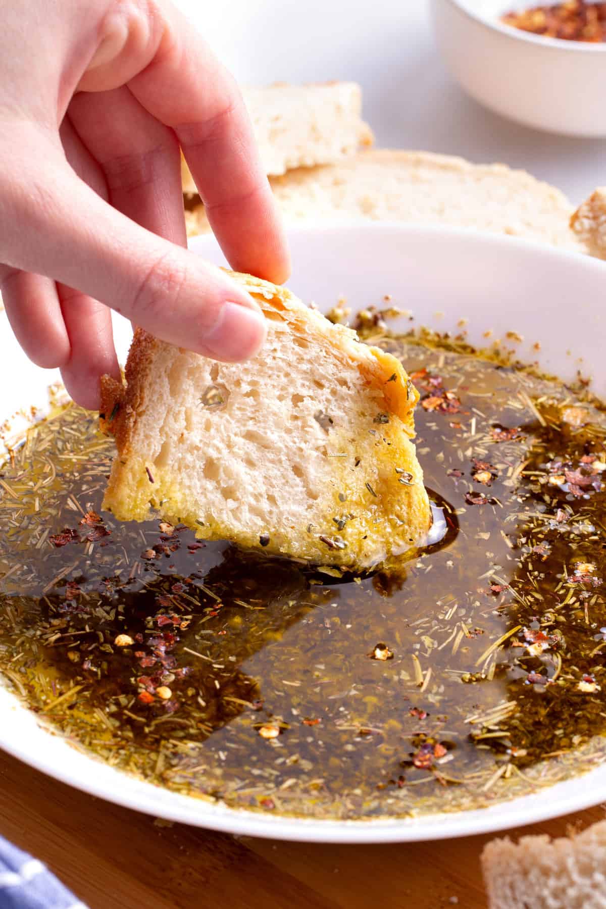 close up image of bread dipping into olive oil bread dip.