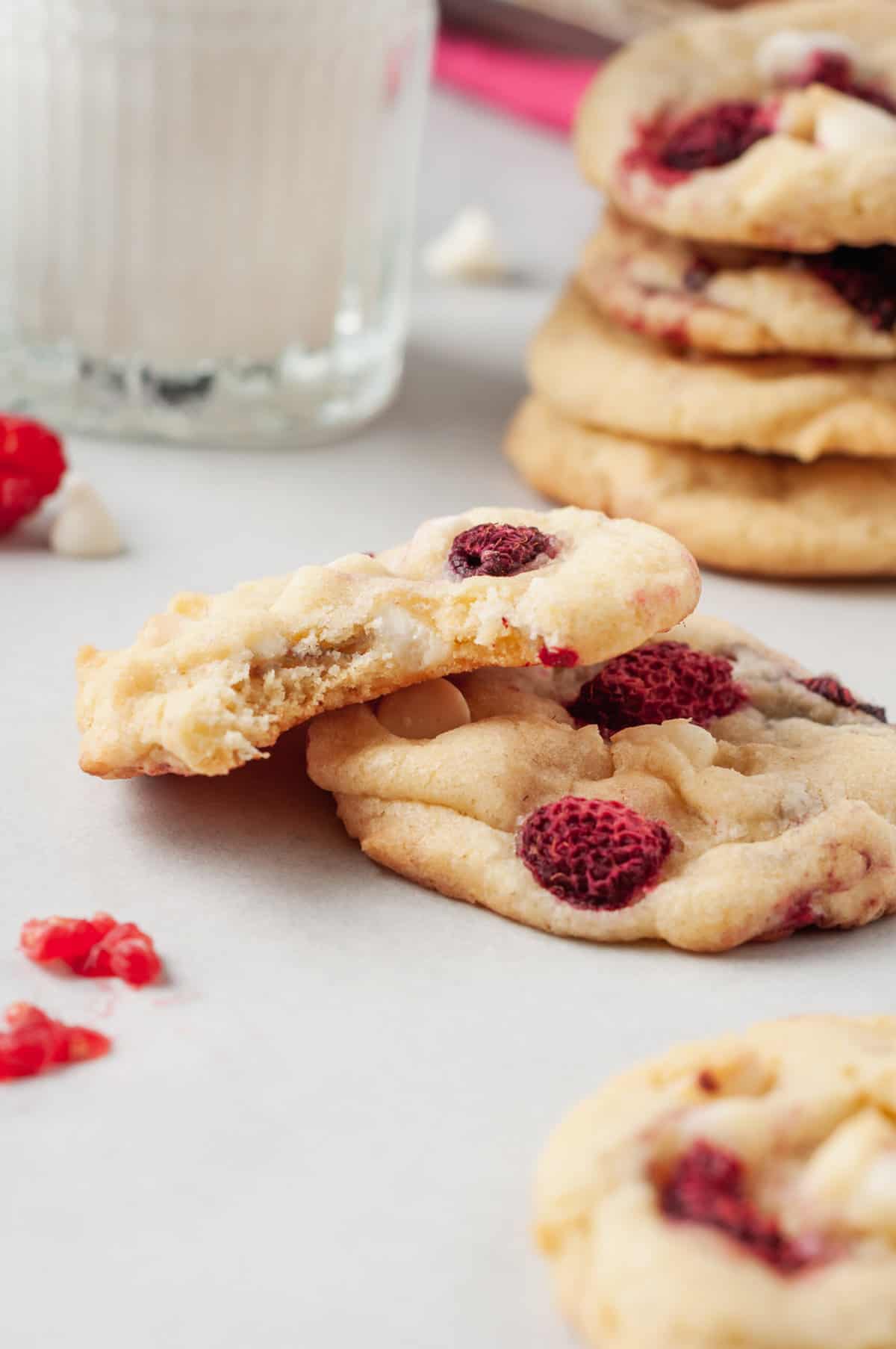 close up image of a stacked raspberry cookie with the top cookie having a bite taken out of it