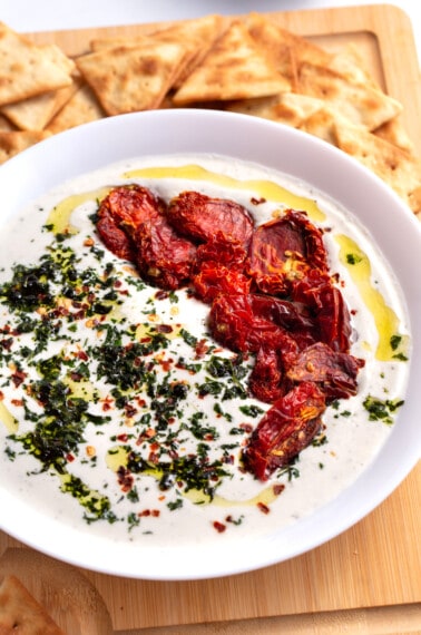 A bowl of whipped feta dip with pita chips.