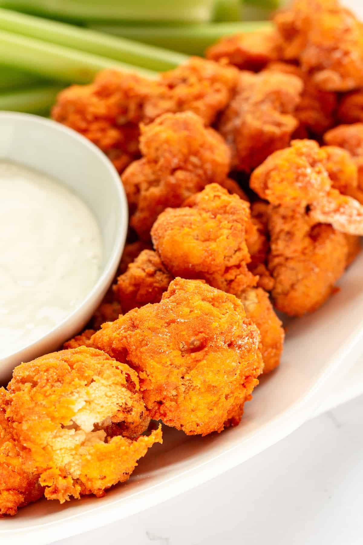 close up image of a plate of air fried buffalo cauliflower with a side of ranch