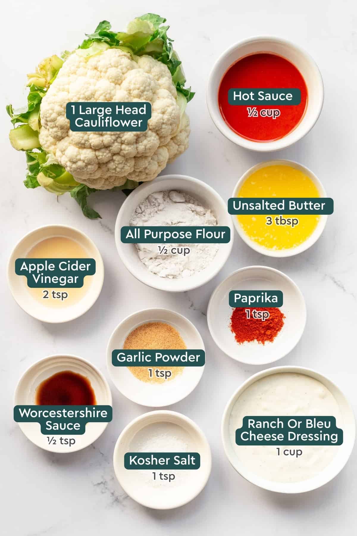 Ingredients for air fryer buffalo cauliflower, including cauliflower, hot sauce, butter, flour, apple cider vinegar, paprika, garlic powder, worcestershire sauce, salt, and dressing.