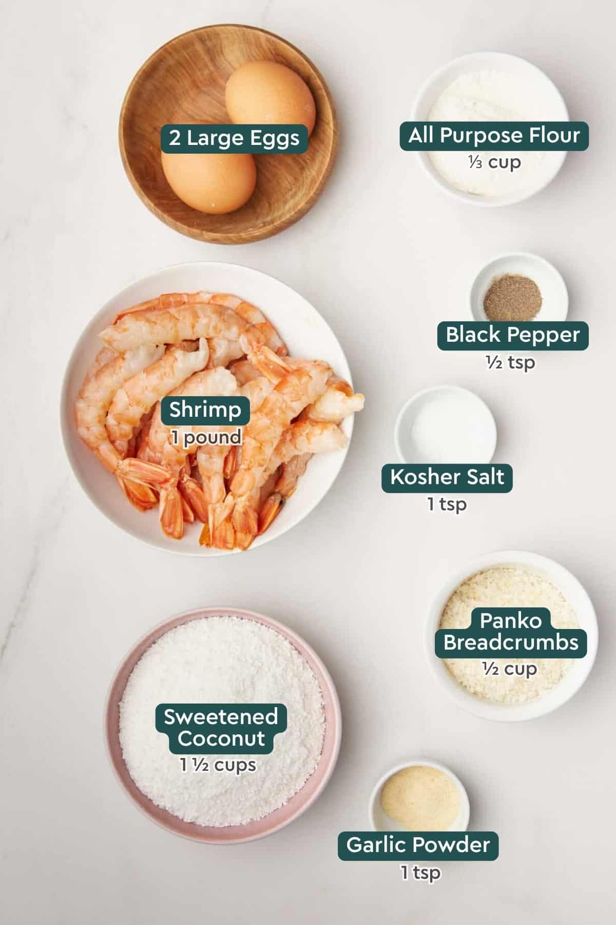 All of the ingredients for air fryer coconut shrimp in bowls on a white countertop.