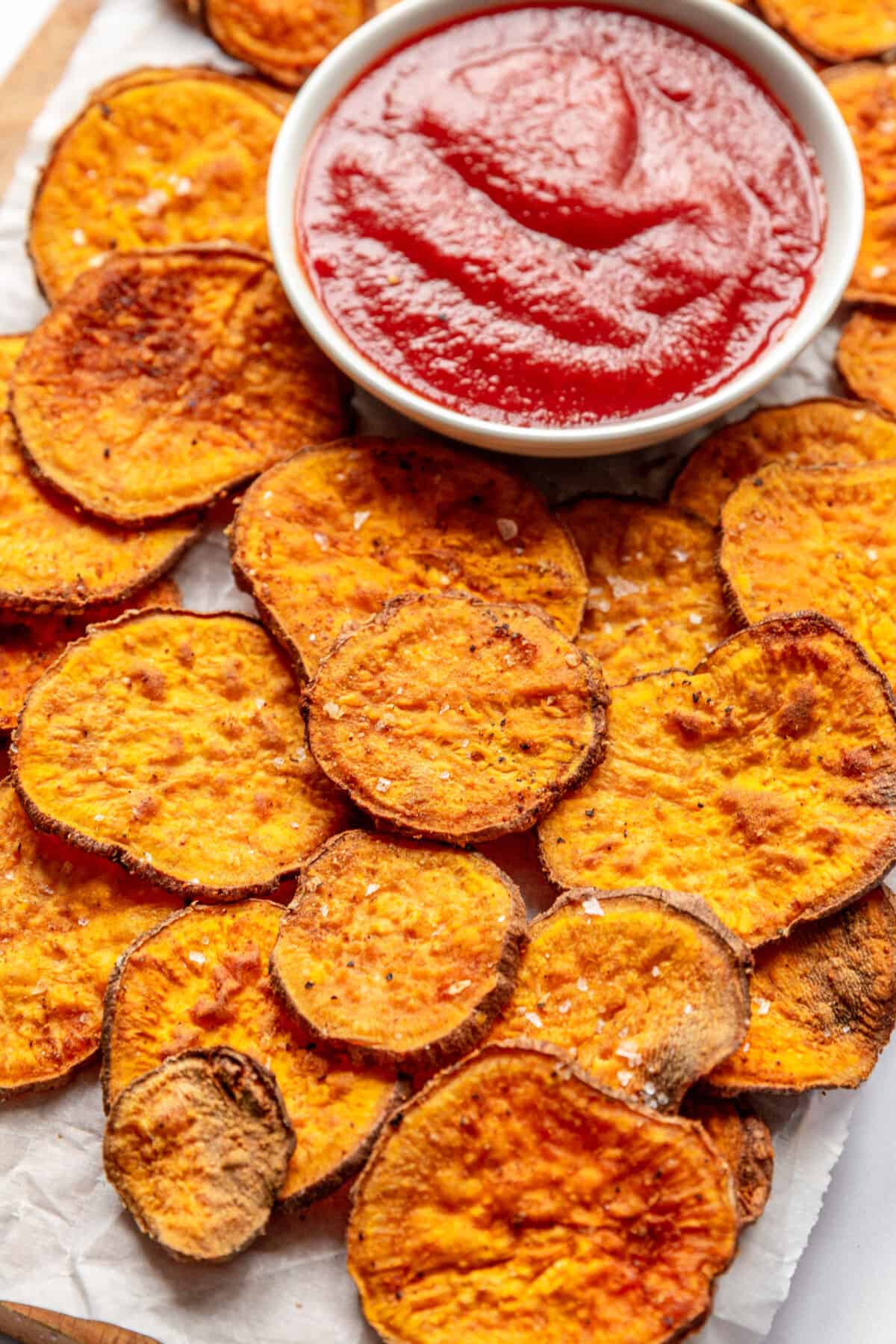 Air fryer sweet potato chips with a side of barbecue sauce.