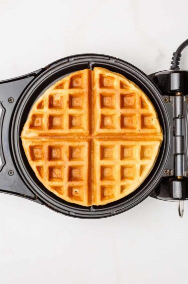 A cooked waffle in a waffle iron.