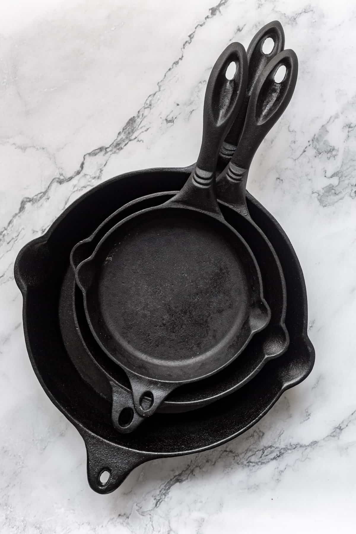top image image of a stack of cast iron pans