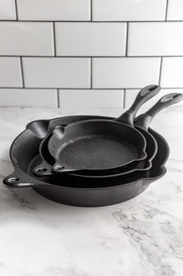 A stack of three cast iron pans.