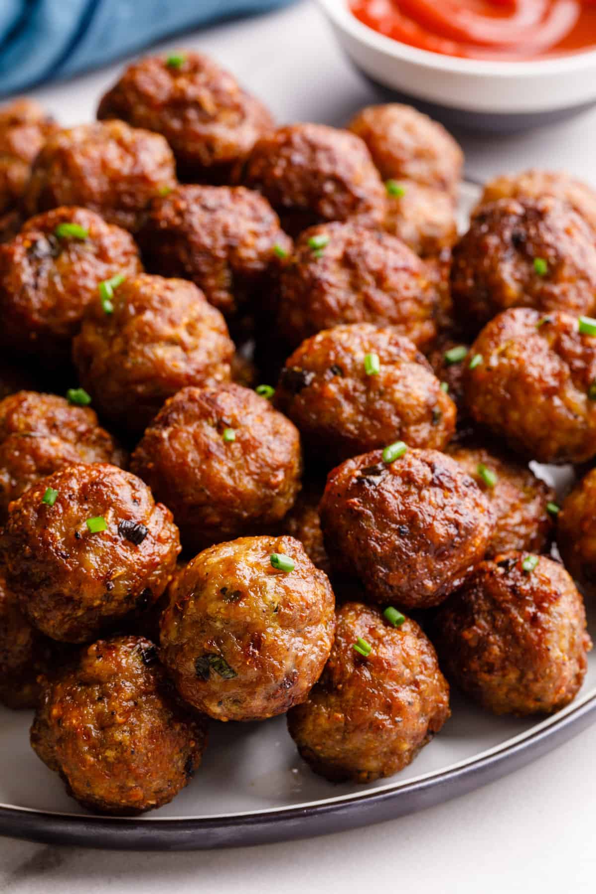 close up image of a pile of air fryer meatballs served on a round plate
