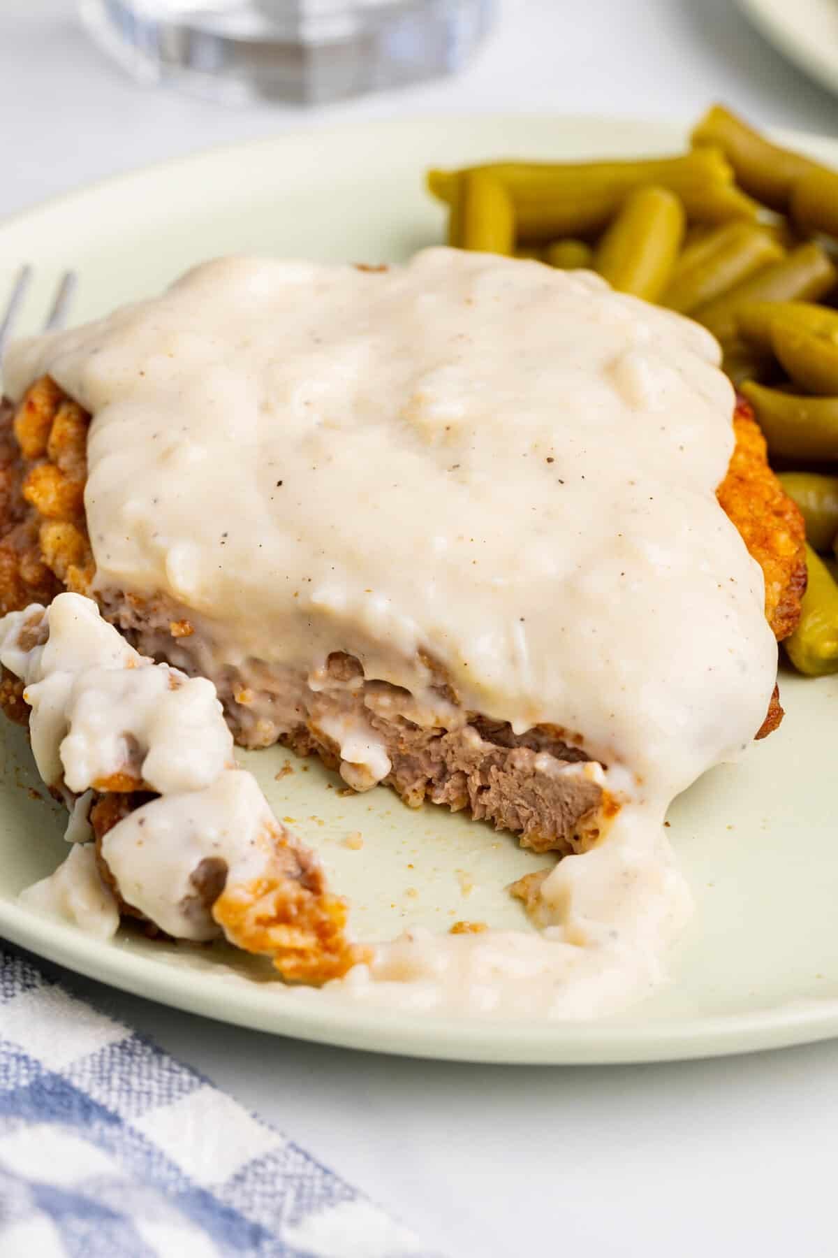 Sliced air fryer chicken fried steak on plate.