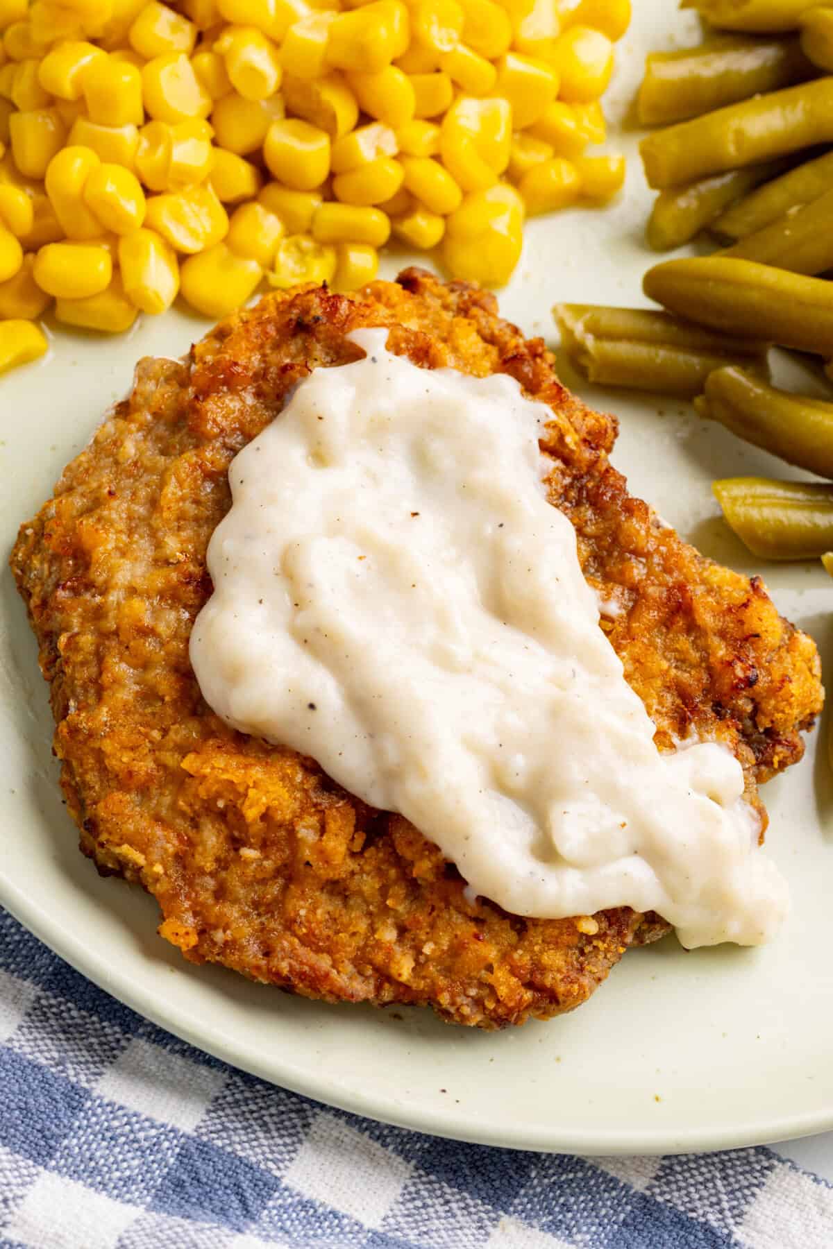 Air fryer chicken fried steak on plate with gravy.