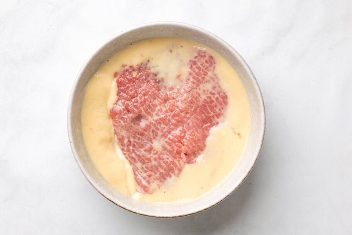 Dredging cube steak in egg mixture.