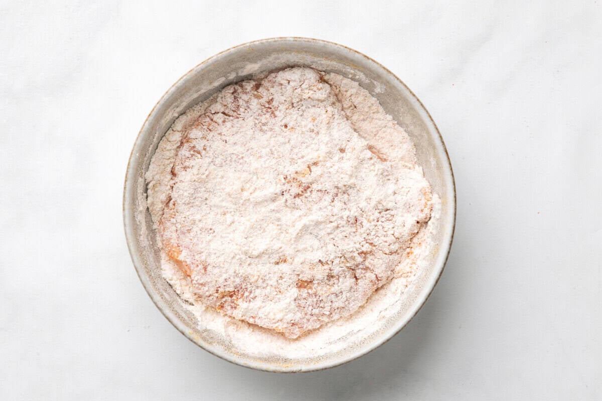 Coating cube steak in flour mixture.