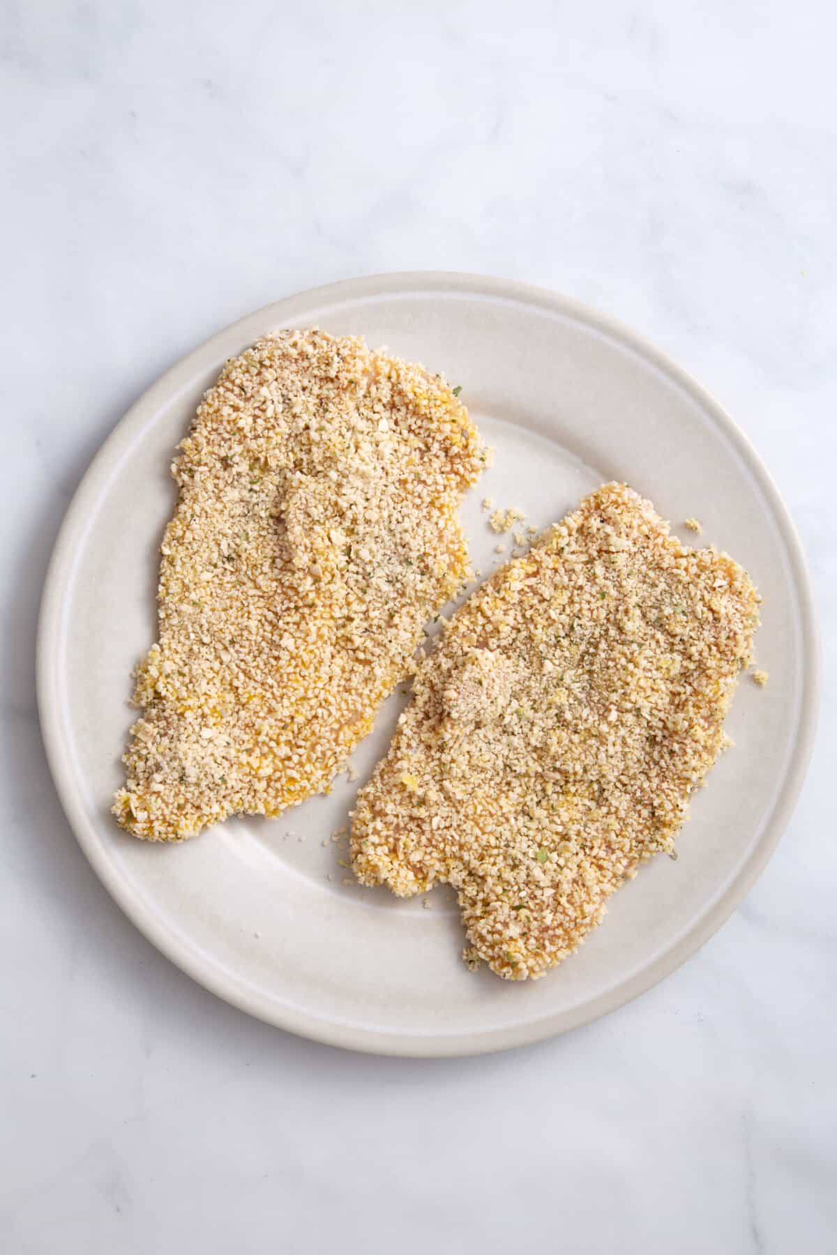 step 3 to make chicken parmesan sandwiches, chicken coated in panko breadcrumbs.