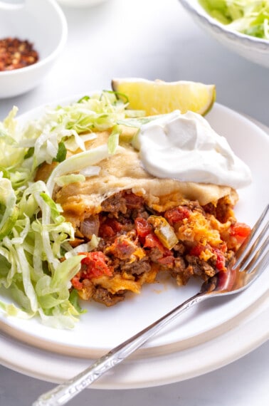 Crescent roll taco bake with lettuce and sour cream on a plate.