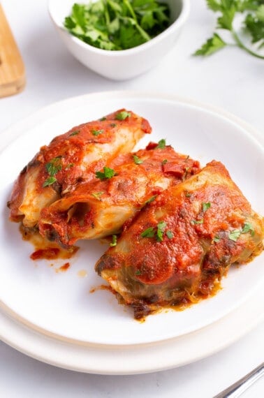 Three slow cooker cabbage rolls on a plate.