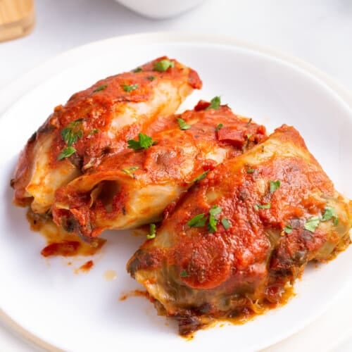 Three slow cooker cabbage rolls on a plate.
