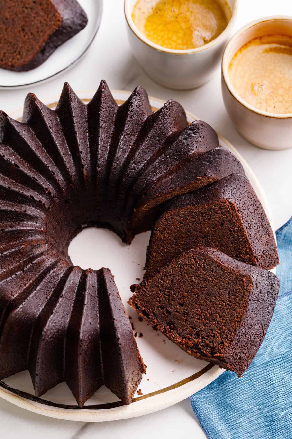 top down image of a chocolate pound cake in a bundt shape sitting on a white round plate