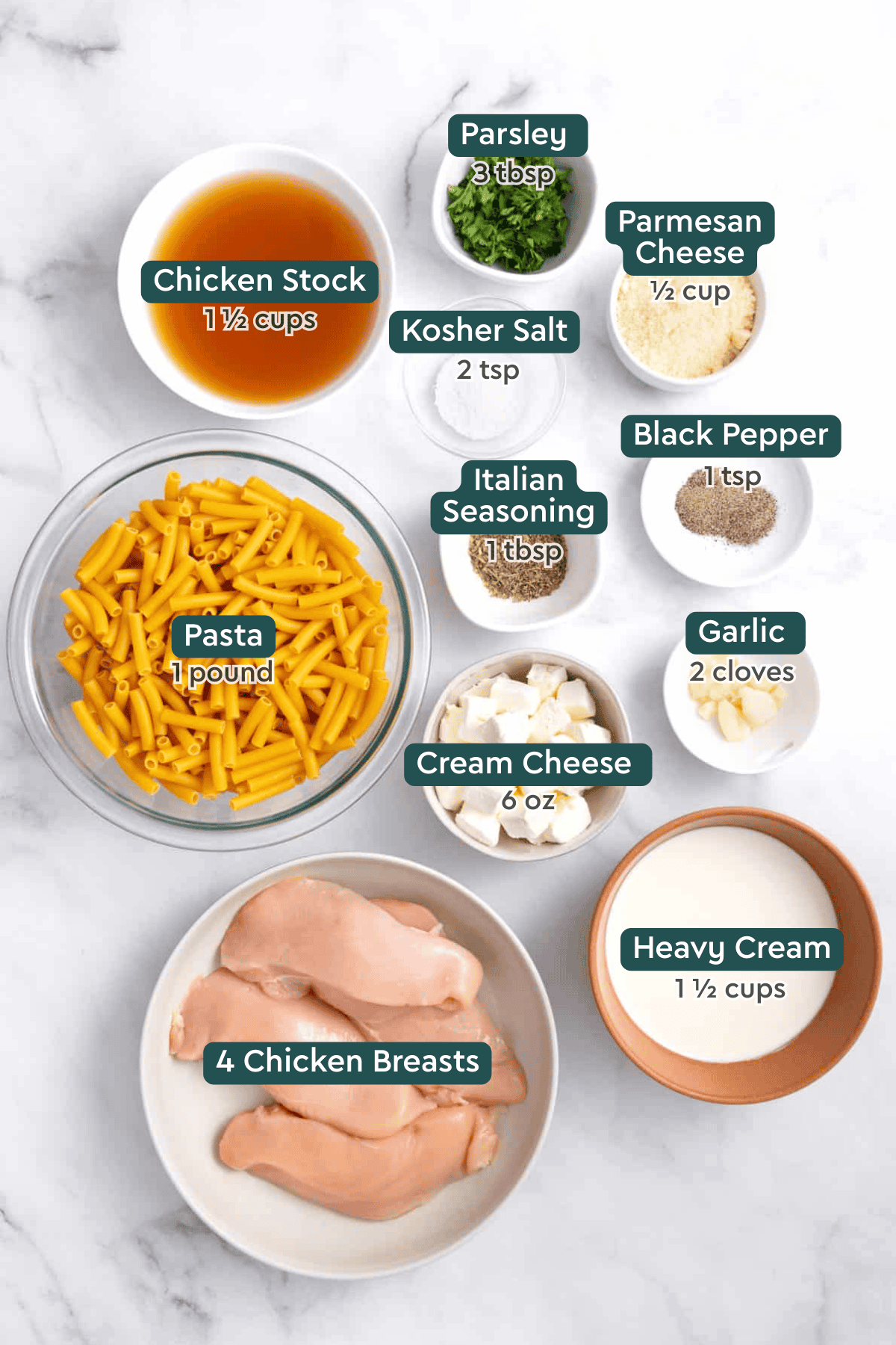All of the ingredients for crockpot chicken alfredo in bowls on a white countertop. 