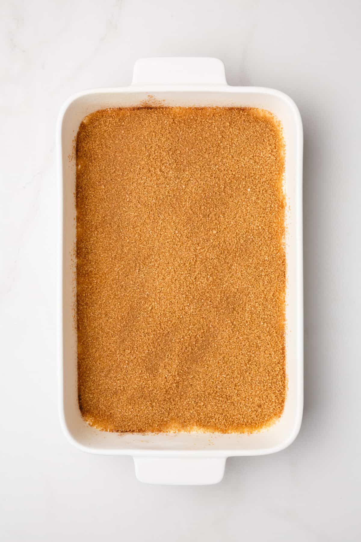 step 2 to make honey bun cake, sprinkle cinnamon sugar mix over the first layer of the cake.
