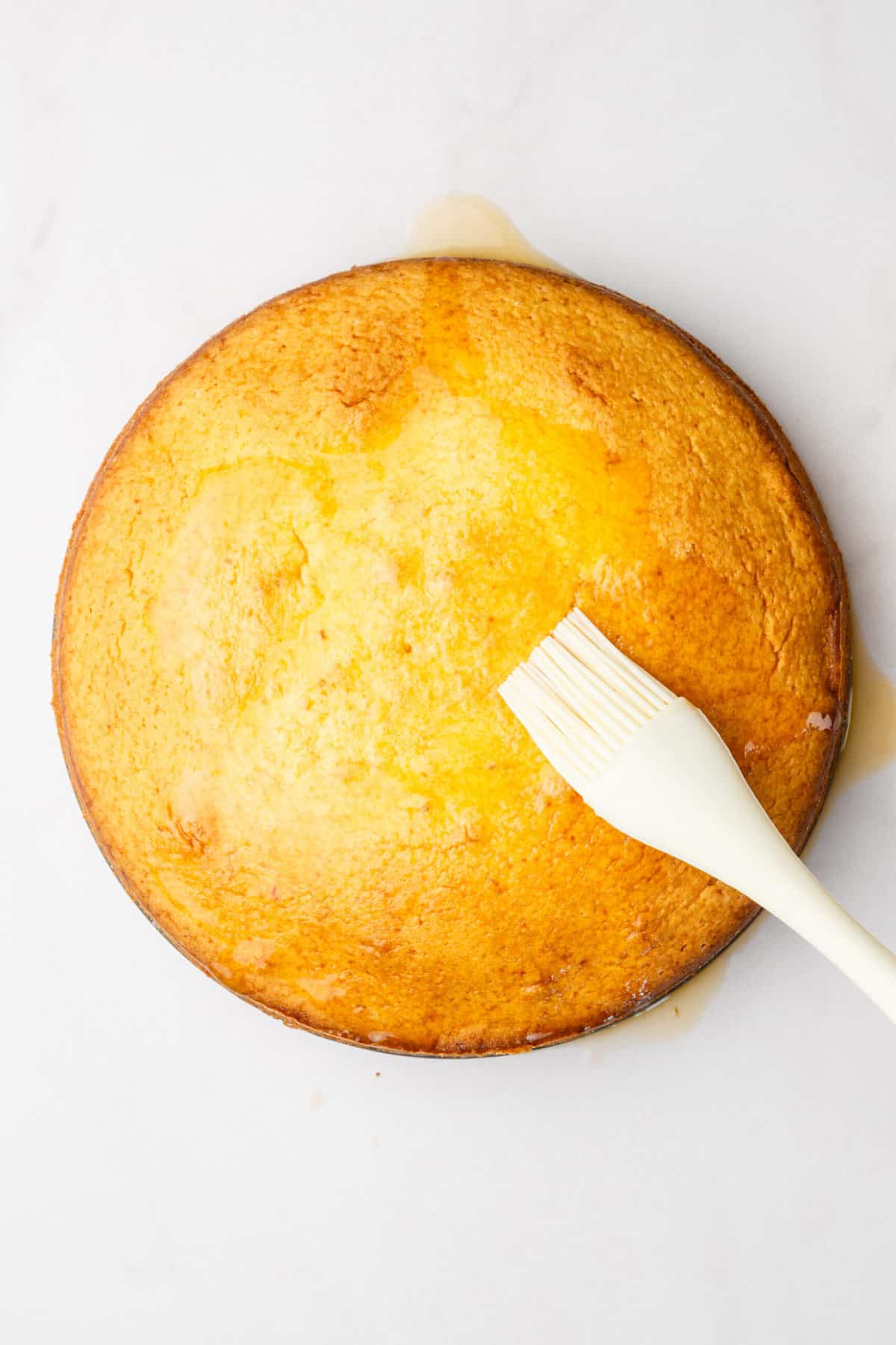 step 6 to make orange cake, use a kitchen brush to drench the orange glaze over the baked orange cake