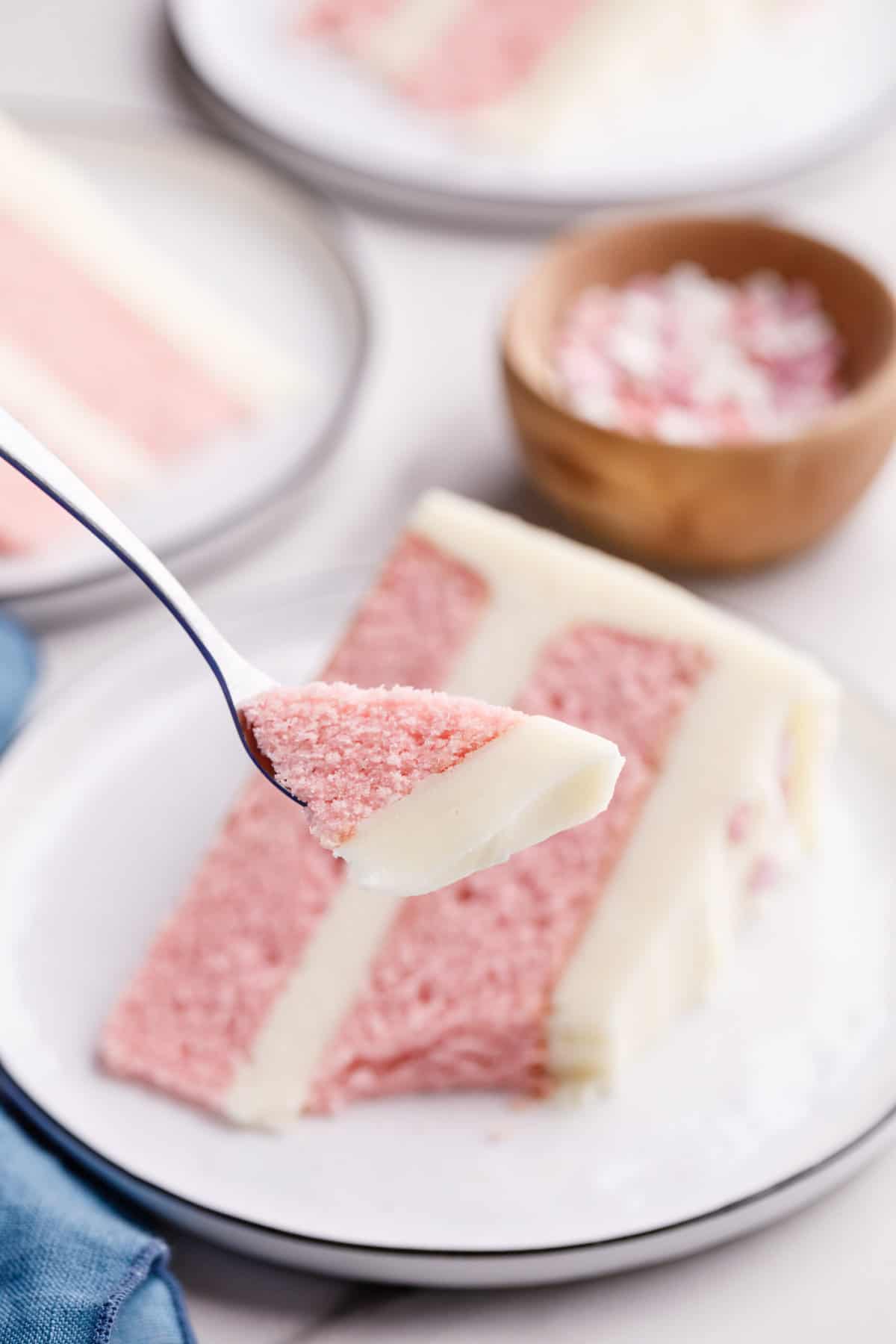 close up of a bite of pink velvet cake sitting on a silver fork