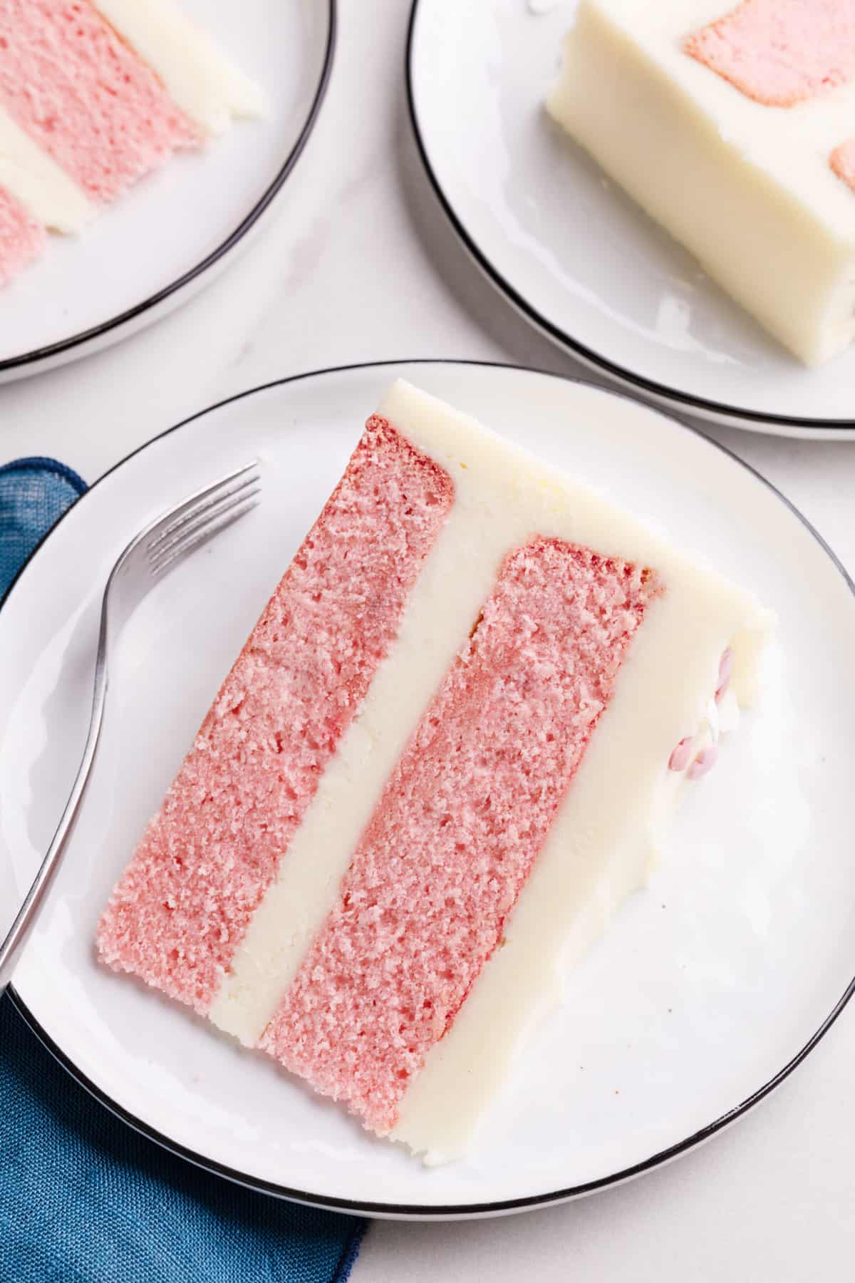 top down image of a slice of pink velvet cake served on a white round plate